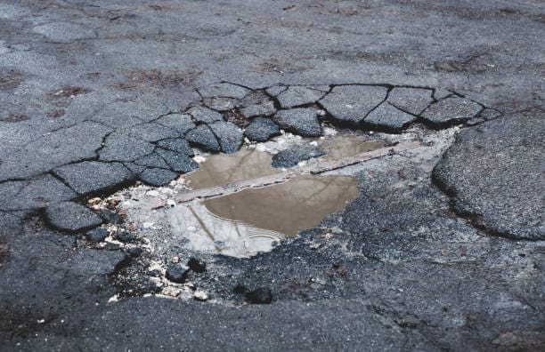 Cracks potholes on bitumen driveway